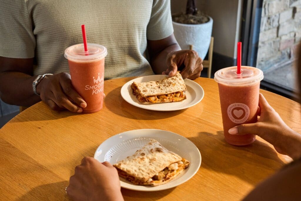 Two people with Smoothie King smoothies and Chicken Flatbreads