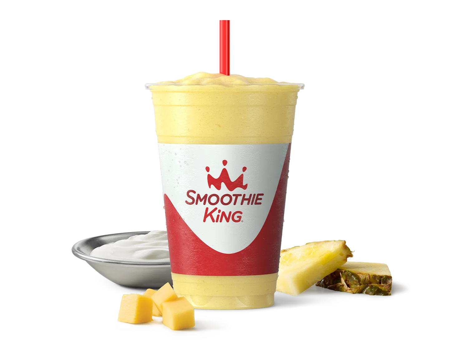 A healthy smoothie with mango chunks and sliced pineapple beside it